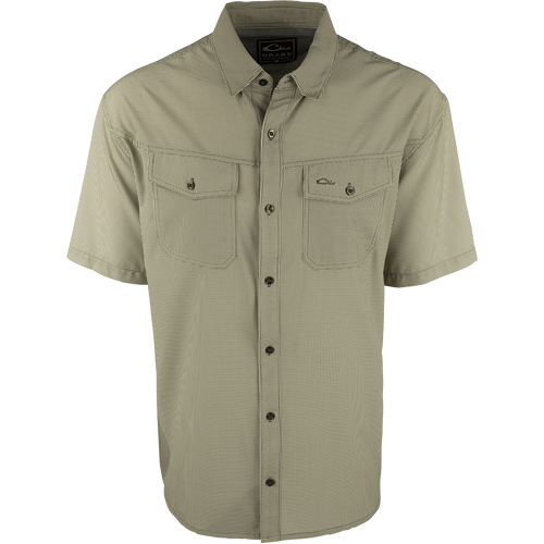 A close-up of the Traveler's Check Shirt S/S, a lightweight and breathable shirt made of polyester and spandex with four-way stretch. Features include moisture-wicking and two chest pockets with button flaps. Perfect for the man on the go.