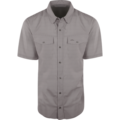 A close-up of the Traveler's Check Shirt S/S, a lightweight and breathable shirt with four-way stretch for freedom of movement. Features moisture-wicking fabric and two chest pockets with button flaps. Ideal for the man on the go.