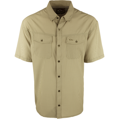 A close-up of the Traveler's Check Shirt S/S, a lightweight and breathable poly/spandex shirt with four-way stretch for freedom of movement. Ideal for the man on the go, it features moisture-wicking technology and 2 chest pockets with button flaps. Perfect for exotic vacations or running around town.