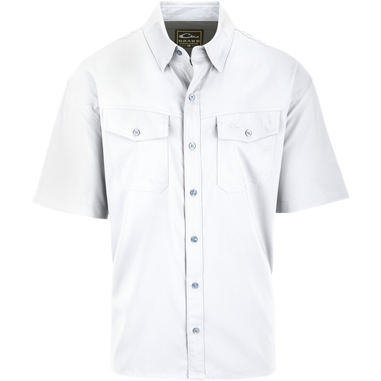 A white shirt with buttons, hidden button-down collar, and two chest pockets. Made of 100% Polyester textured dobby fabric, it's lightweight, moisture-wicking, and offers UPF30 sun protection. The Traveler's Solid Dobby Shirt S/S is versatile for any occasion.