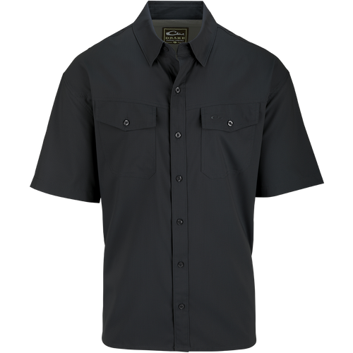 A black button-up shirt with hidden collar buttons, chest pockets, and a split tail hem. Made from 100% Polyester dobby fabric, it offers UPF30 sun protection and moisture-wicking properties. Versatile for any occasion. From Drake Waterfowl, high-quality hunting gear and clothing.
