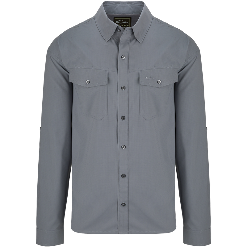 A versatile Traveler's Solid Dobby Shirt L/S with hidden button-down collar, chest pockets, and split tail hem. Featherweight, moisture-wicking fabric with UPF30 sun protection.