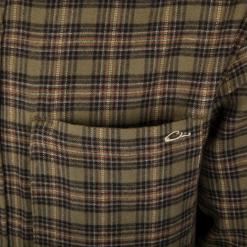 A person wearing the Autumn Brushed Twill Shirt, a plaid shirt made from 100% brushed cotton twill. Features a left chest pocket with a hidden zippered pocket behind and a button-down collar. Perfect for fall and winter outdoor days.
