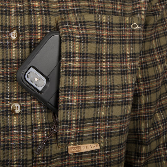 A close-up of a cell phone in a pocket of the Autumn Brushed Twill Shirt, featuring a hidden zippered vertical chest pocket.