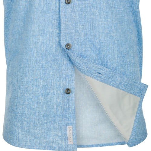 A blue and white short with buttons, made of 100% polyester micro mesh fabric for natural cooling and quick drying. Features include UPF30 sun protection, hidden button-down collar, and two front chest pockets. Perfect for performance and comfort, whether on the water or at the office. From Drake Waterfowl, a store known for high-quality hunting gear and signature casual apparel.