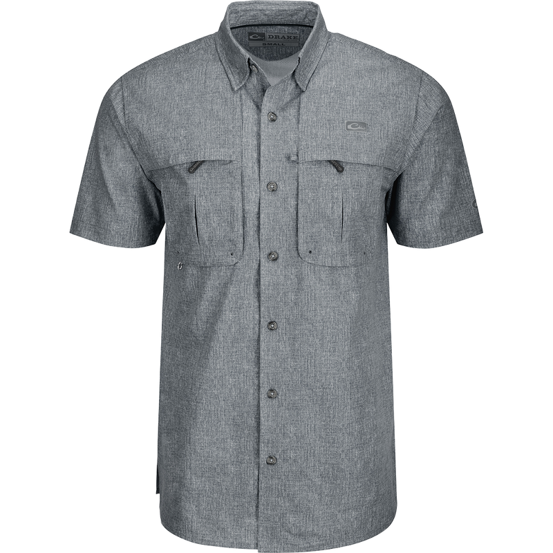A grey Heritage Heather Shirt with pockets, made of 100% polyester micro mesh for natural cooling and quick drying. Features include a hidden button-down collar, vented cape back, and two front chest pockets. Perfect for performance and comfort in any setting.