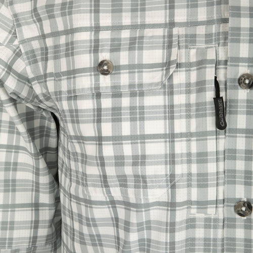 Hunter Creek Window Pane Plaid Shirt L/S: A close-up of a button-up shirt made from lightweight, moisture-wicking micro-mesh fabric with hidden collar buttons, vented back, and chest pockets with zip and Magnattach closures.