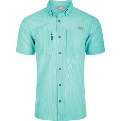 Classic Seersucker Stripe Shirt S/S: A close-up of a soft, featherweight shirt with a seersucker texture. Features include UPF 30 sun protection, moisture-wicking, and a button-down collar. It has a hidden zippered right chest pocket and a left chest pocket with a Magnattach™ closure. The vented cape back provides additional ventilation, and the split tail hem allows for versatile styling. The image shows the shirt's pattern and fabric.