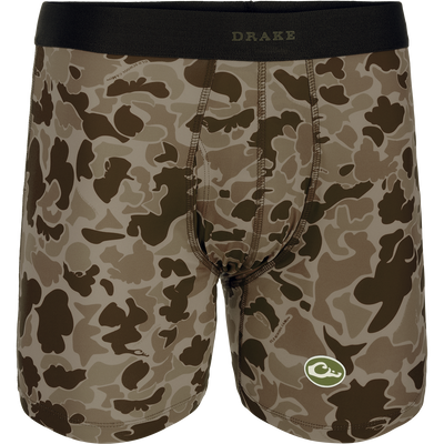 A close-up of the Commando Boxer Brief, featuring a camouflage pattern and a green and white logo. Comfortable, moisture-wicking fabric with four-way stretch for freedom of movement. Elastic waistband and functional fly. Perfect for hunting and outdoor activities.
