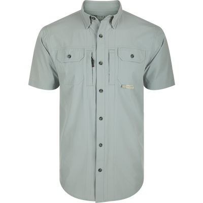 Wingshooter Trey Shirt S/S: Close-up of performance shirt with hidden collar, chest pockets, and vented back, featuring technical fabric and functional design: Quarry