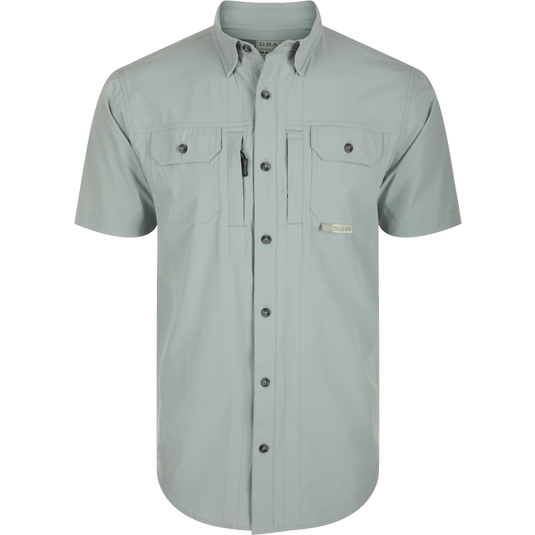 Wingshooter Trey Shirt S/S: Close-up of performance shirt with hidden collar, chest pockets, and vented back, featuring technical fabric and functional design: Quarry