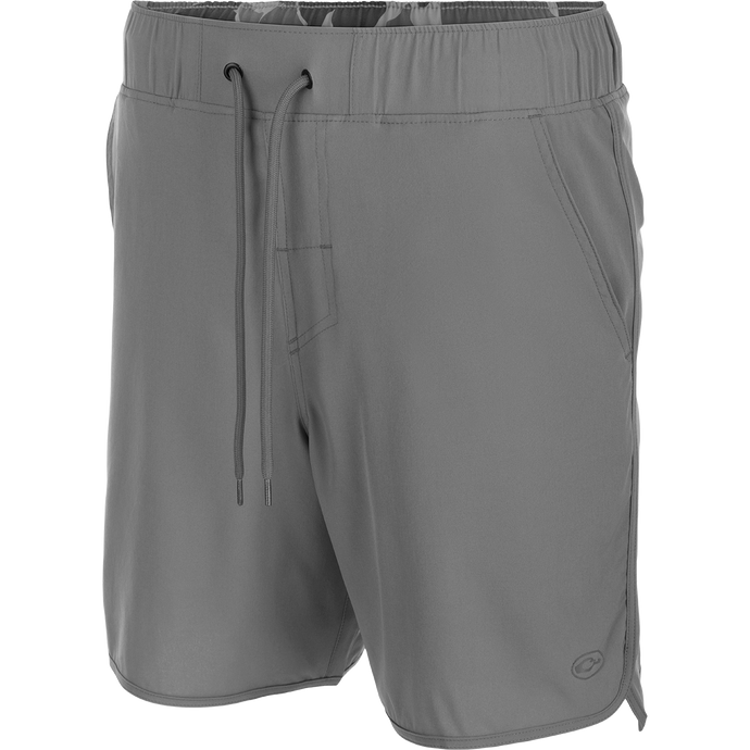 A versatile grey shorts with a drawstring, featuring a 7-inch inseam and built-in liner. Made with 4-way stretch, quick-drying fabric, and moisture-wicking properties. Includes front and back pockets with hidden zippers. Perfect for beach to bar outings. From Drake Waterfowl.