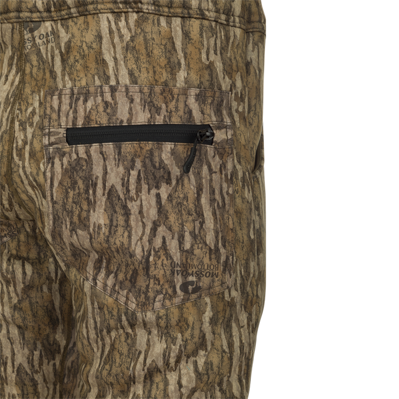 A close-up of the MST Ultimate Wader Bib, featuring camouflage pants, a pocket, and a zipper.