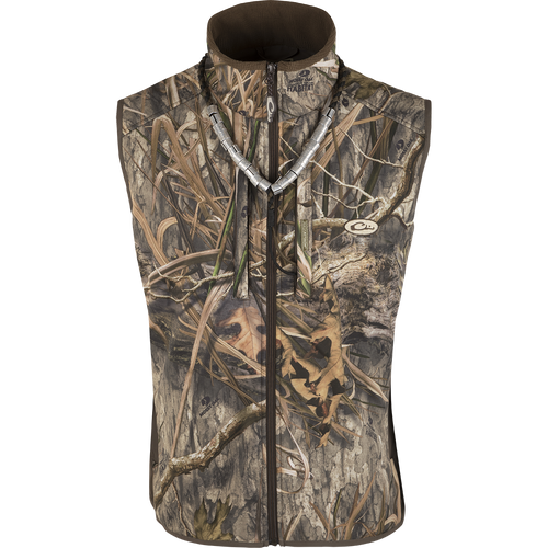 A close-up of the EST Camo Windproof Tech Vest, a vest with a camouflage pattern. It features a Magnattach™ chest pocket, zippered pockets, and a drawstring waist. Perfect for hunting and mild temperatures.