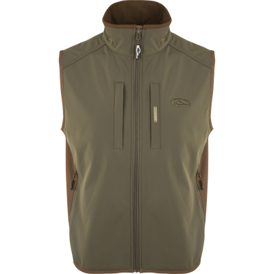 EST Windproof Tech Vest, featuring a logo and zipper details. This khaki vest is made of high-quality polyester tech shell and bonded fleece lining with a windproof membrane. It's perfect for outdoor activities and can be worn as a core or outer layer. Stay warm and stylish with this versatile vest from Drake Waterfowl.