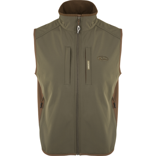 EST Windproof Tech Vest, featuring a logo and zipper details. This khaki vest is made of high-quality polyester tech shell and bonded fleece lining with a windproof membrane. It's perfect for outdoor activities and can be worn as a core or outer layer. Stay warm and stylish with this versatile vest from Drake Waterfowl.