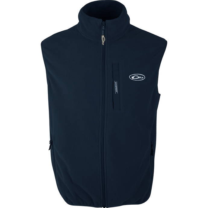 A lightweight poly-fleece vest with a white logo, perfect for layering under your favorite Drake outerwear. Moisture-wicking and highly breathable, it's ideal for any Spring or Fall outfit. Features include anti-pill treatment, vertical Magnattach™ pocket, and lower zippered hand warmer pockets.