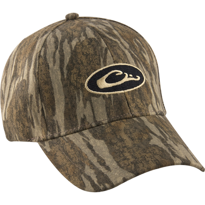 Camo Cotton Cap with logo, perfect for outdoor enthusiasts. Lightweight and comfortable, it features camo concealment under the bill to reduce glare. Six-panel construction and hook and loop closure for a secure fit. Made with 100% cotton. From Drake Waterfowl, your go-to store for high-quality hunting gear and clothing.