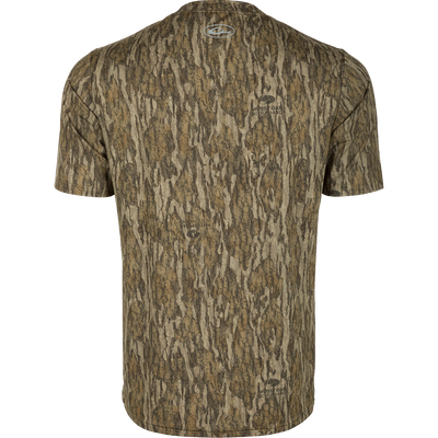 Youth EST Camo Performance Short Sleeve Crew, a back of a shirt with a logo close-up. Ideal for outdoor activities with 4-Way Stretch, Shield 4 Sun™ UPF 50+, Shield 4 Coolant™, Shield 4 Odor™, and Shield 4 Stains™ treatments.