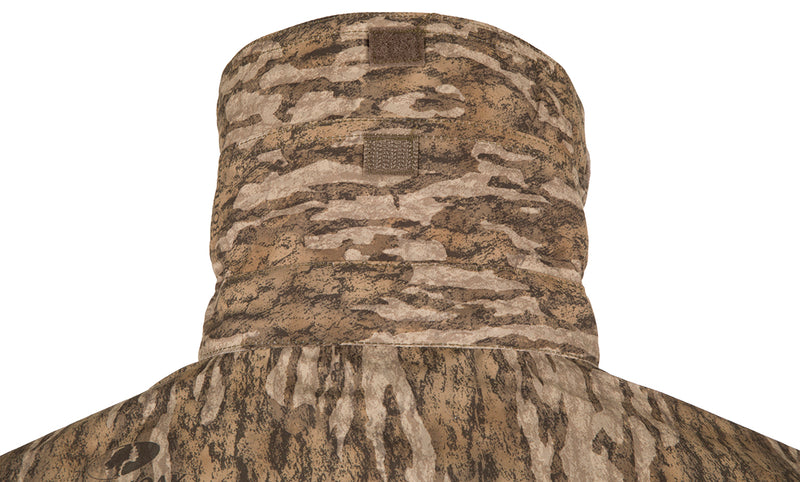 A lightweight camouflaged jacket with a hood, designed for maximum breathability on hunts and shooting range activities. Features include vents, breathable mesh, and button tabs on sleeves. Perfect for dove hunts, teal and goose hunts, or a day at the shooting range.