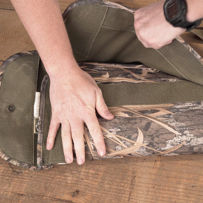 A person's hand on a camouflage Side-Opening Gun Case.