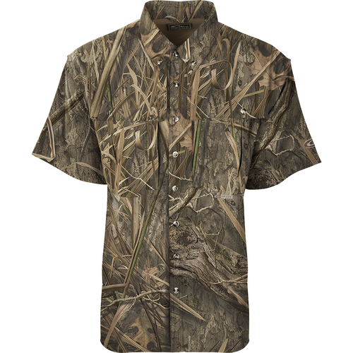 A close-up of the EST Camo Flyweight Wingshooter's Shirt S/S, a lightweight and breathable hunting shirt made of 100% polyester. Features include Sol-Shield™ UPF 50+ sun protection, back heat vents, mesh side panels, Magnattach™ vertical chest pocket, and quick-drying fabric.