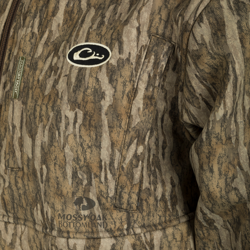A close-up of the MST Hole Shot Hooded Windproof Eqwader Full Zip Jacket, featuring a black and white logo. This jacket has a 3-layer upper body and hood for wind protection, while the sherpa-lined bonded breathable lower body keeps you warm.