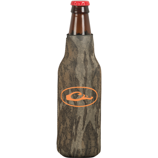 A brown glass bottle with a red cap, featuring an orange logo on a grey surface. The bottle cooler has a side zipper for a snug fit and a separate bottom piece to prevent tipping over.