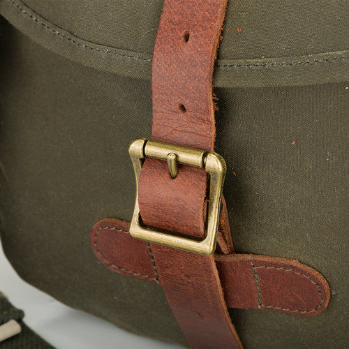 McAlister Wingshot Ditty Bag: A close-up of a brown leather strap with a brass buckle, perfect for hunting. Durable materials and spacious compartments make it ideal for carrying essential necessities.