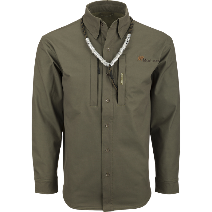 McAlister Microfleece Softshell Waterfowler's Shirt: A green long-sleeved shirt with a necklace, perfect for fluctuating weather conditions. Features include windproof softshell fabric, ample pocket storage, and comfortable range of motion.