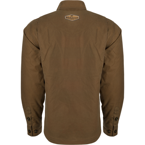 McAlister Waxed Cotton Jac-Shirt, a brown jacket with a white logo on it. Water and wind-resistant, with a heritage look and functional fit. Fleece-lined hand pockets.