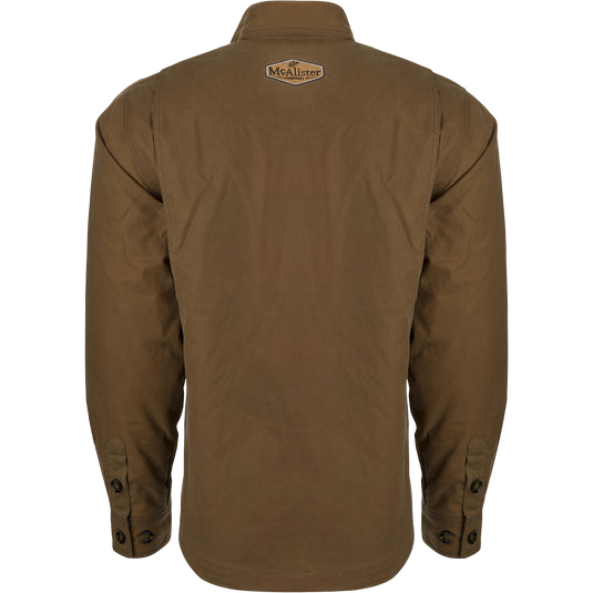 McAlister Waxed Cotton Jac-Shirt, a brown jacket with a white logo on it. Water and wind-resistant, with a heritage look and functional fit. Fleece-lined hand pockets.