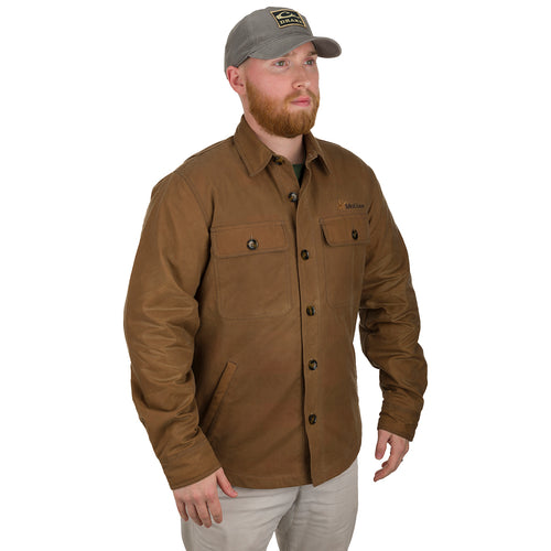 McAlister Waxed Cotton Jac-Shirt: A man wearing a hat and brown jacket, with a close-up of his face. He has a beard and his hand is in the jacket's pocket.