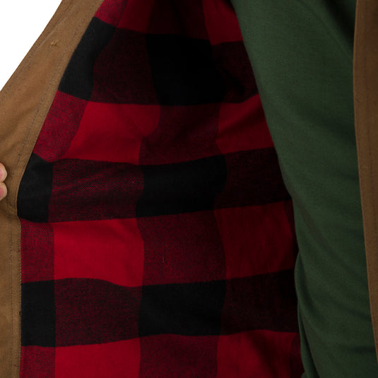 A person opening the McAlister Waxed Cotton Jac-Shirt, revealing a red and black plaid flannel lining. Water and wind-resistant with a heritage look and functional fit. Fleece-lined hand pockets.
