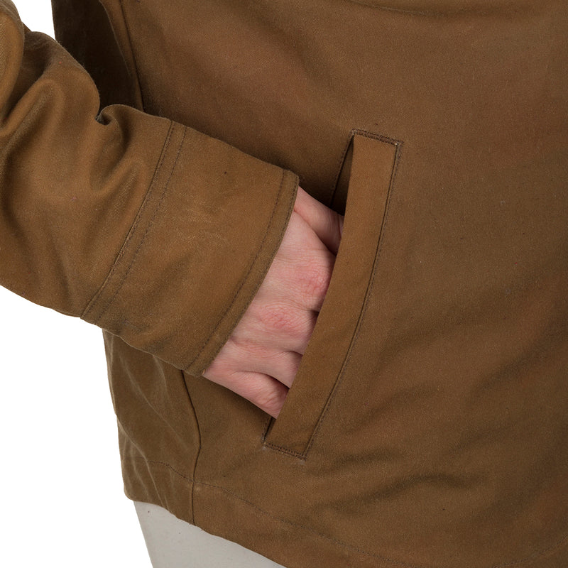 A person's hand in the pocket of a McAlister Waxed Cotton Jac-Shirt, showcasing the functional fit and heritage look of this water and wind-resistant outerwear.