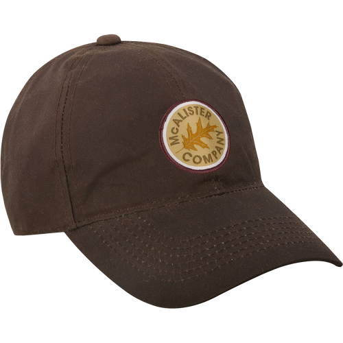 A McAlister Waxed Cotton Baseball Cap with embroidered logo. Features 10 oz waxed cotton and adjustable Velcro closure. Ideal for hunting and outdoor activities.