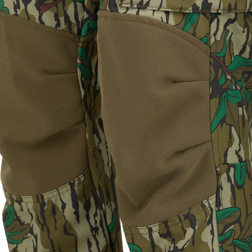 A close-up of the Women's Tech Stretch Turkey Pant, featuring a camouflage pattern. Designed for spring turkey hunting, these lightweight, moisture-wicking pants offer 4-way stretch and reinforced knees for durability. Stay comfortable and concealed in the woods with a relaxed fit and adjustable waistband. Mesh and zippered pockets provide ventilation and storage for hunting essentials.