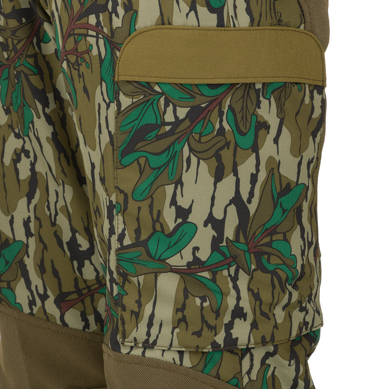A close-up of the Youth Tech Stretch Turkey Pant, featuring a camouflage pattern and reinforced knees. Designed for comfort and durability during outdoor activities.
