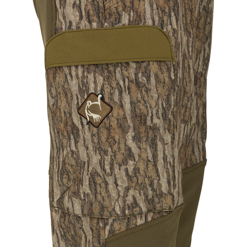 A close-up of the Men's Tech Stretch Turkey Hunting Pant, featuring a camouflage pattern and reinforced knees. Designed for spring turkey season, these lightweight and moisture-wicking pants offer 4-way stretch and durability. Perfect for slipping through the woods or remaining concealed during long waits.