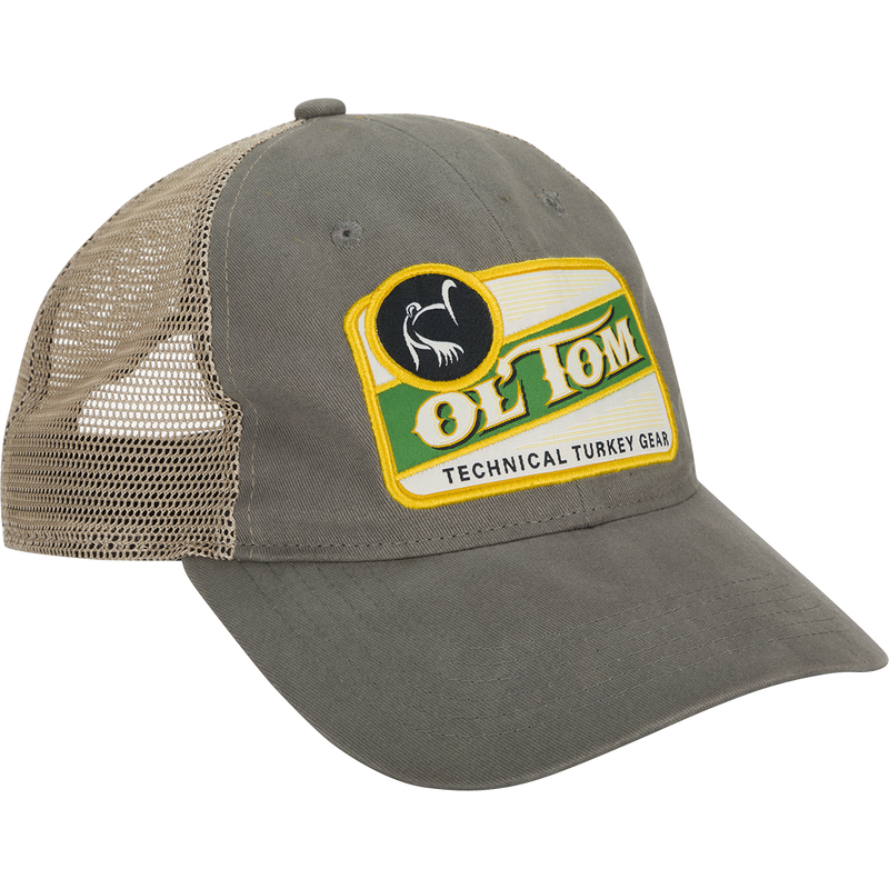 Ol' Tom Vintage Patch Mesh Back Cap, a grey hat with a logo on it. Unstructured cotton twill front and bill, combined with a soft polyester mesh back. Adjustable snapback and slightly pre-curved visor.