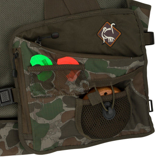 Youth Time & Motion Easy-Rider Turkey Vest: Close-up of bag with pockets, toy, and detachable seat cushion. Quick-draw shell loops, designated call pockets, adjustable straps. High-quality hunting gear for turkey hunting.
