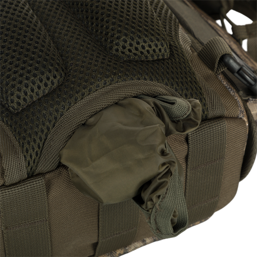 A lightweight Turkey Chest Pack made of durable materials, featuring a close-up of a bag with multiple pockets, loops, and a stowable rain fly for complete protection. Perfect for your next hunting trip.