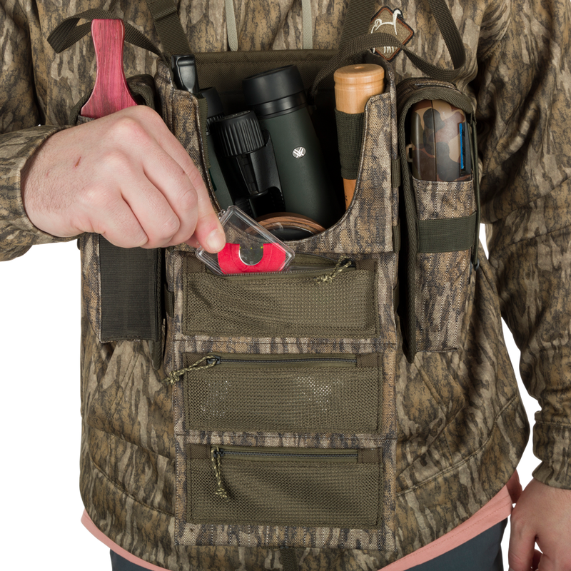 A person wearing the Turkey Chest Pack, a camouflage vest with a bag full of hunting essentials.