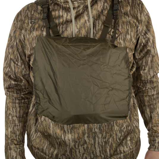 A person wearing the Turkey Chest Pack, a camouflage jacket with multiple pockets and loops for hunting.