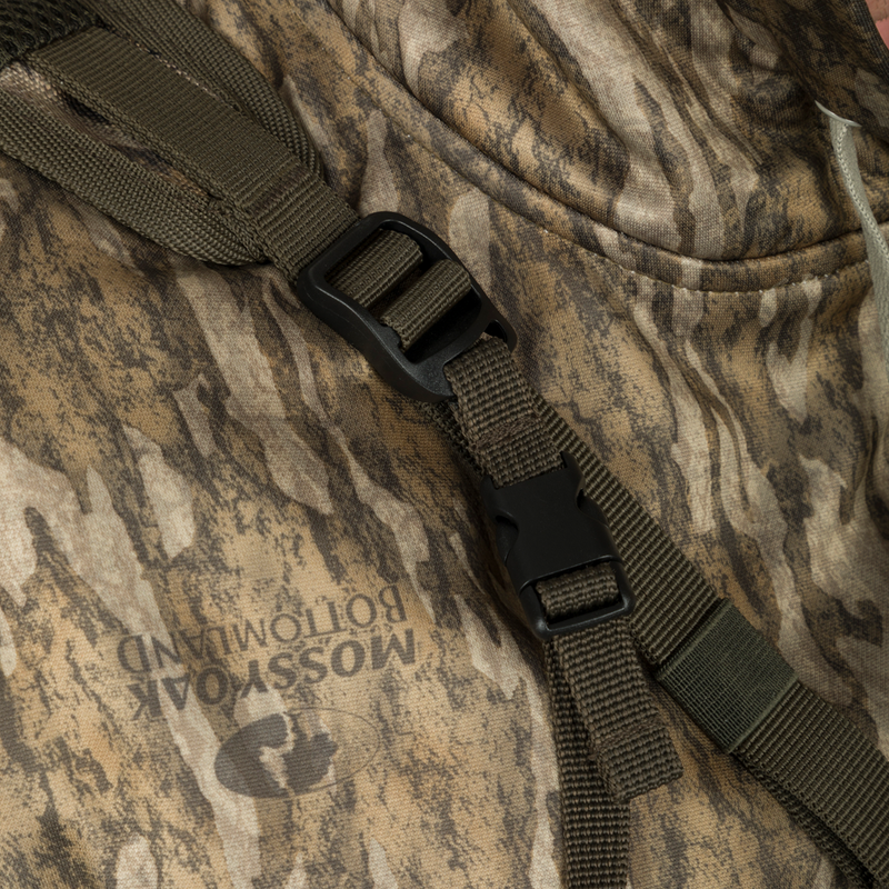 A close-up of the Turkey Chest Pack, featuring a strap on a camouflage jacket with a black buckle. Perfect for your next hunting trip.