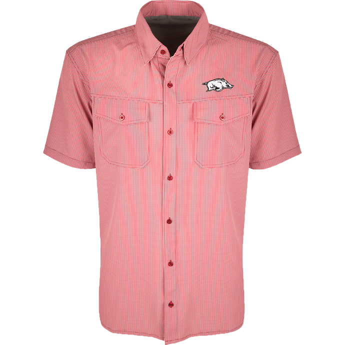 Arkansas S/S Traveler's Shirt, a red and white checkered shirt with a pig on it. Lightweight, breathable fabric with four-way stretch for comfort. Moisture-wicking, wrinkle-resistant construction. Features 2 chest pockets with button flaps. Ideal for early season baseball games or weekend tailgates.
