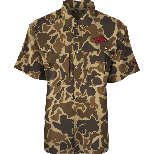 Arkansas S/S Flyweight Wingshooter: A camouflage shirt with a red pig, featuring quick-drying, moisture-wicking fabric, UPF 50+ sun protection, vented back design, and multiple pockets. Ideal for warm-weather outdoor activities.