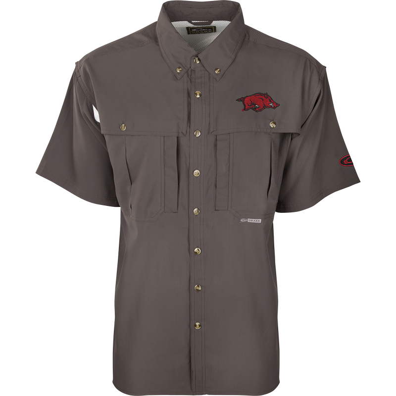 Arkansas S/S Flyweight Wingshooter: A grey shirt with a logo, designed for warm-weather outdoor activities. Features vented back, quick-drying fabric, UPF 50+ sun protection, and multiple pockets.