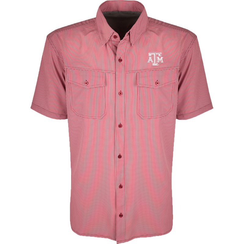 A red and white plaid shirt with four-way stretch for freedom of movement and ultimate comfort. Lightweight and wrinkle resistant, perfect for early season football games or weekend tailgates. Features moisture-wicking fabric and two chest pockets with button flaps. Texas A&M logo embroidered on the left chest.