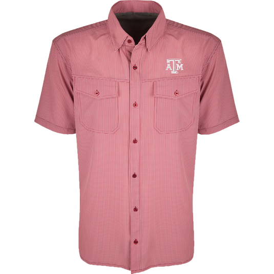 A red and white plaid shirt with four-way stretch for freedom of movement and ultimate comfort. Lightweight and wrinkle resistant, perfect for early season football games or weekend tailgates. Features moisture-wicking fabric and two chest pockets with button flaps. Texas A&M logo embroidered on the left chest.
